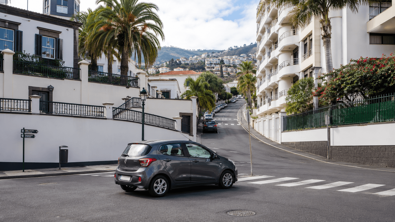 Compact car on a hilly urban street in Funchal Madeira